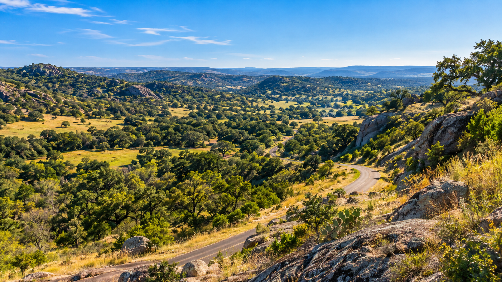 Rolling Texas Hill Country ranchland and a winding paved road near Willow City